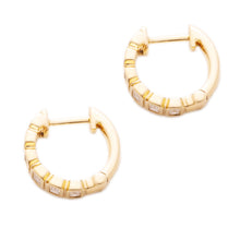 These 14k yellow gold huggy earrings feature baguette cut diamonds ...