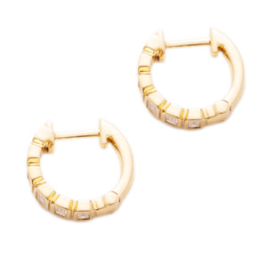 These 14k yellow gold huggy earrings feature baguette cut diamonds ...