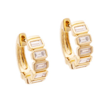 These 14k yellow gold huggy earrings feature baguette cut diamonds ...