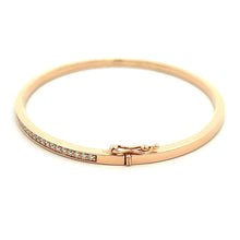 This 14k rose gold diamond bangle features round brilliant cut diam...