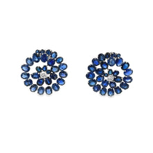 These 18k white gold earrings feature sapphires and diamonds that f...